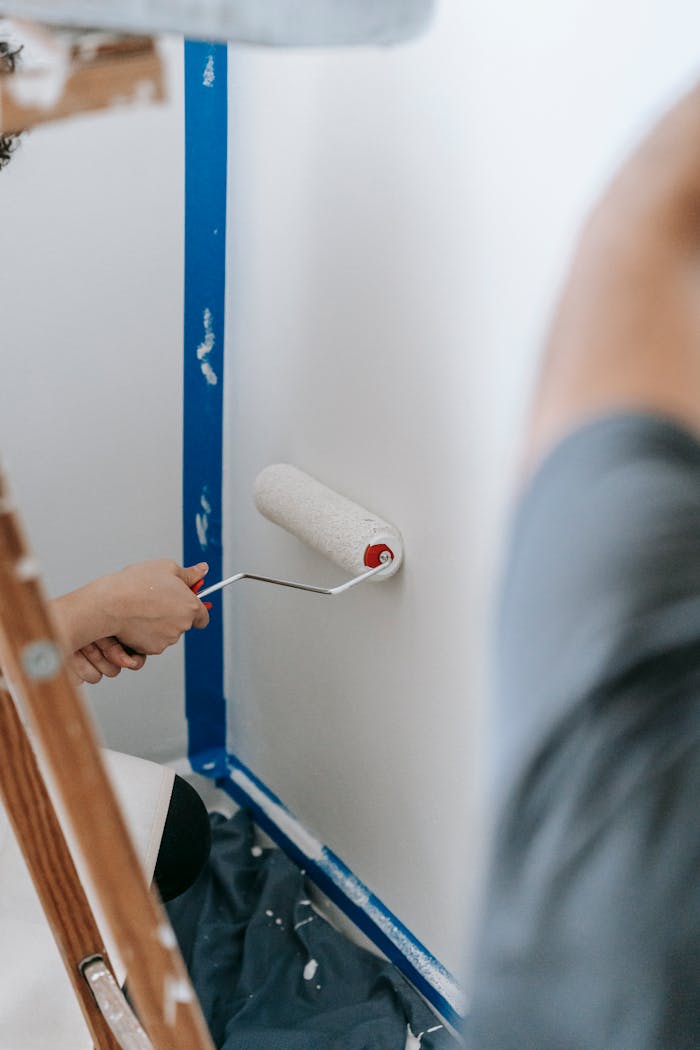 People Painting A Wall